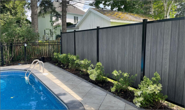 Clôture en composite sur cadre acier, installation adaptée terrain en pente, Québec